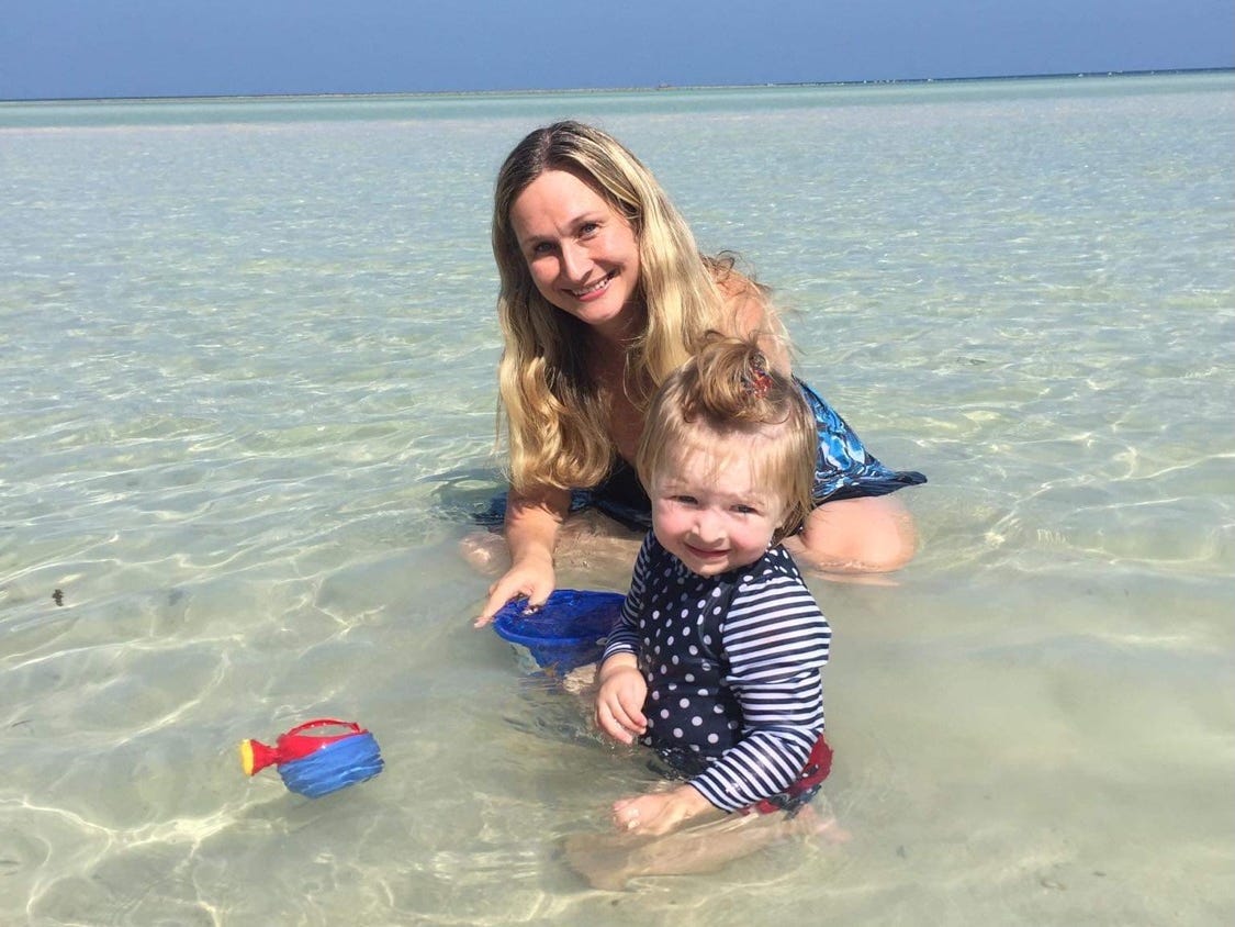 A woman and her toddler playing in the water at the beach in Koh Samui, Thailand.