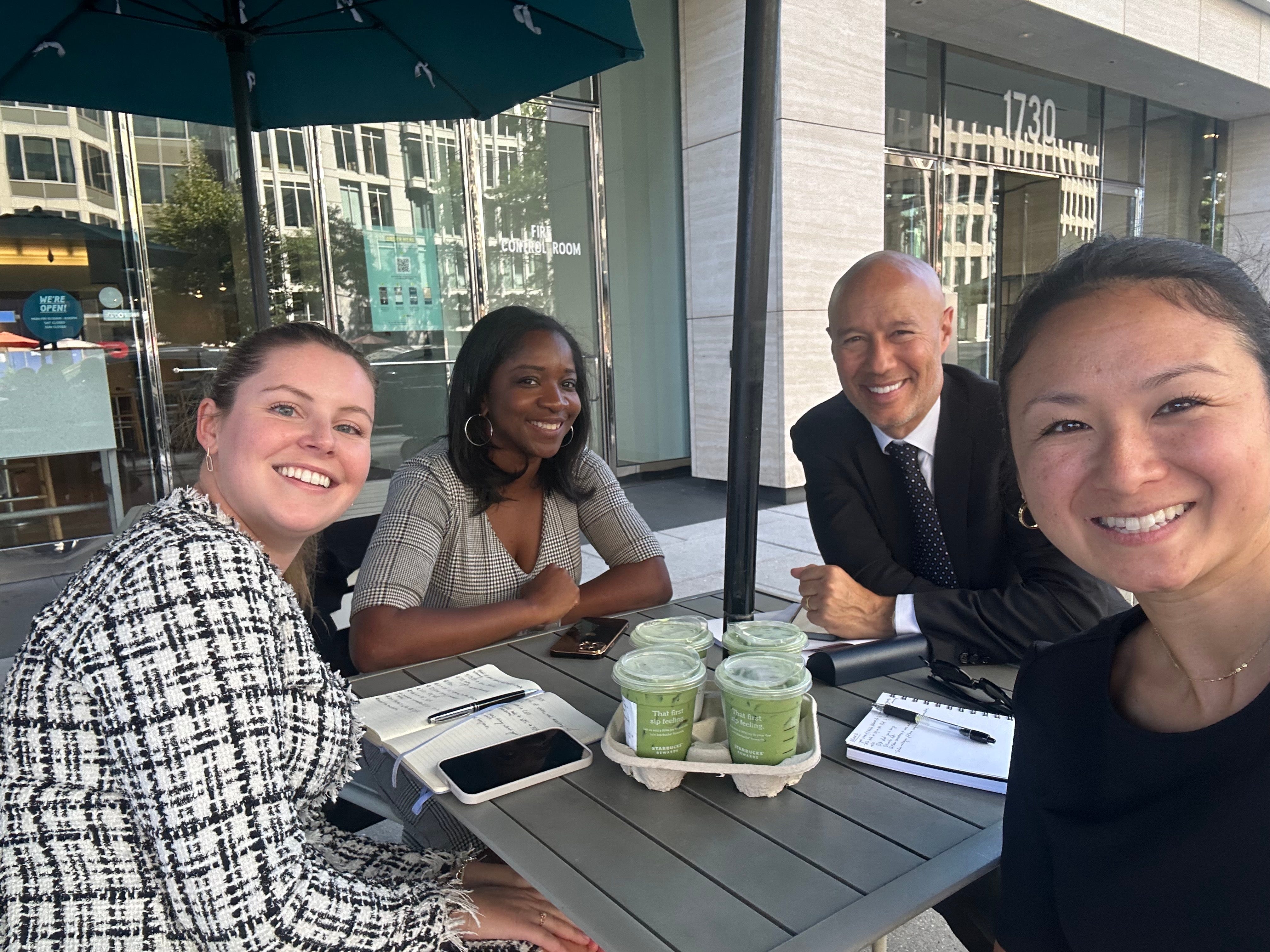David Risher poses for a selfie at a table of four employees