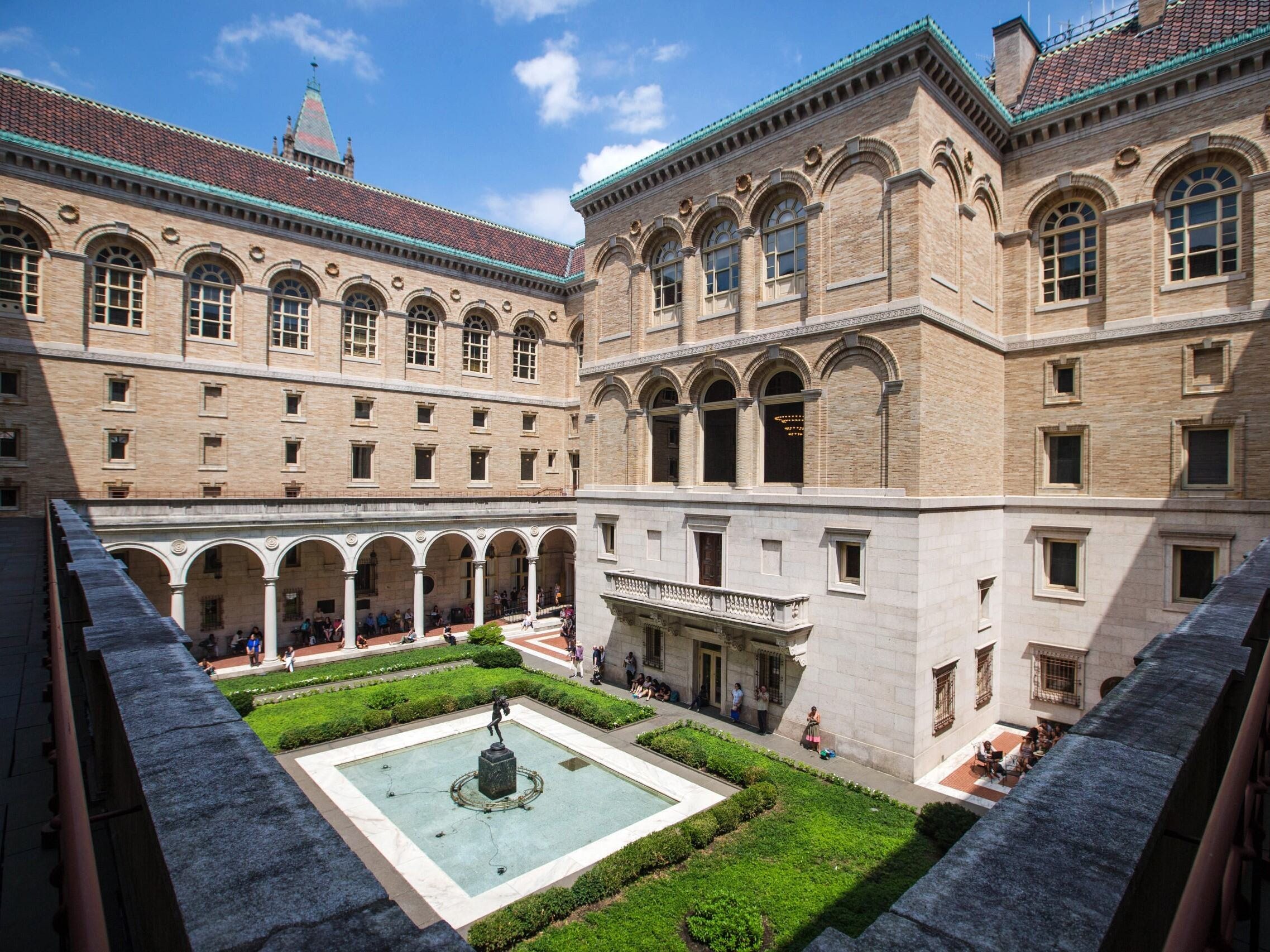 A photo from a balcony at the Boston Public Library, overlooking a courtyard with greenery and a fountain.