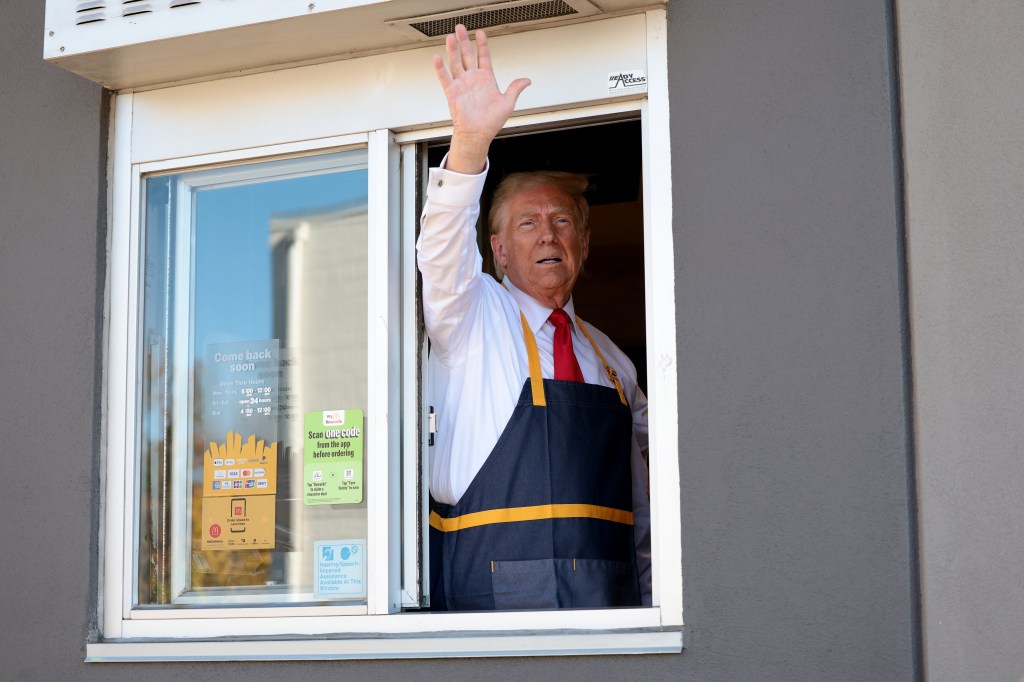 Donald Trump waving from a McDonald's drive-thru window.
