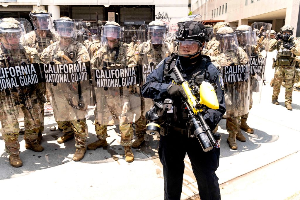 California National Guard troops in riot gear facing protesters.