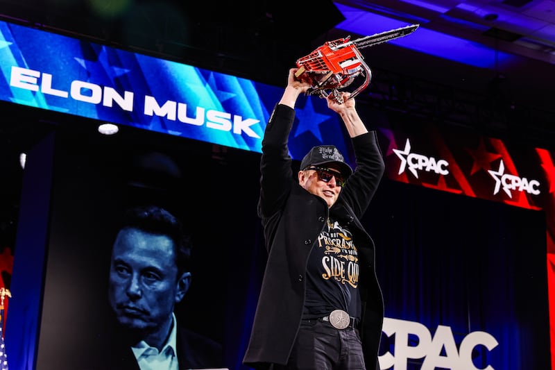 Elon Musk holds a a personalized chainsaw given by Argentine President Javier Milei at the Conservative Political Action Conference (CPAC) in February.