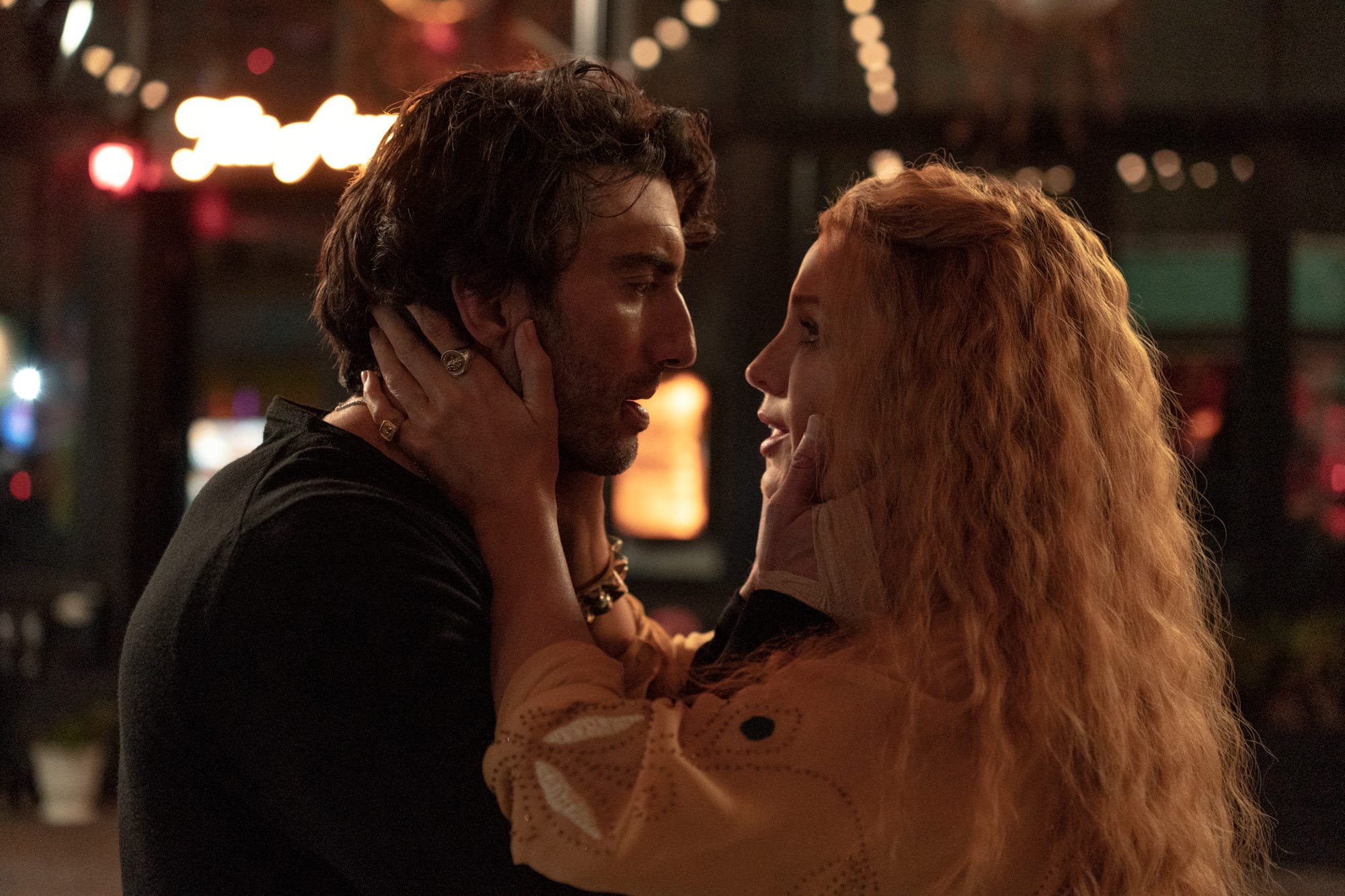 Justin Baldoni and Blake Lively holding each other's faces in a scene from