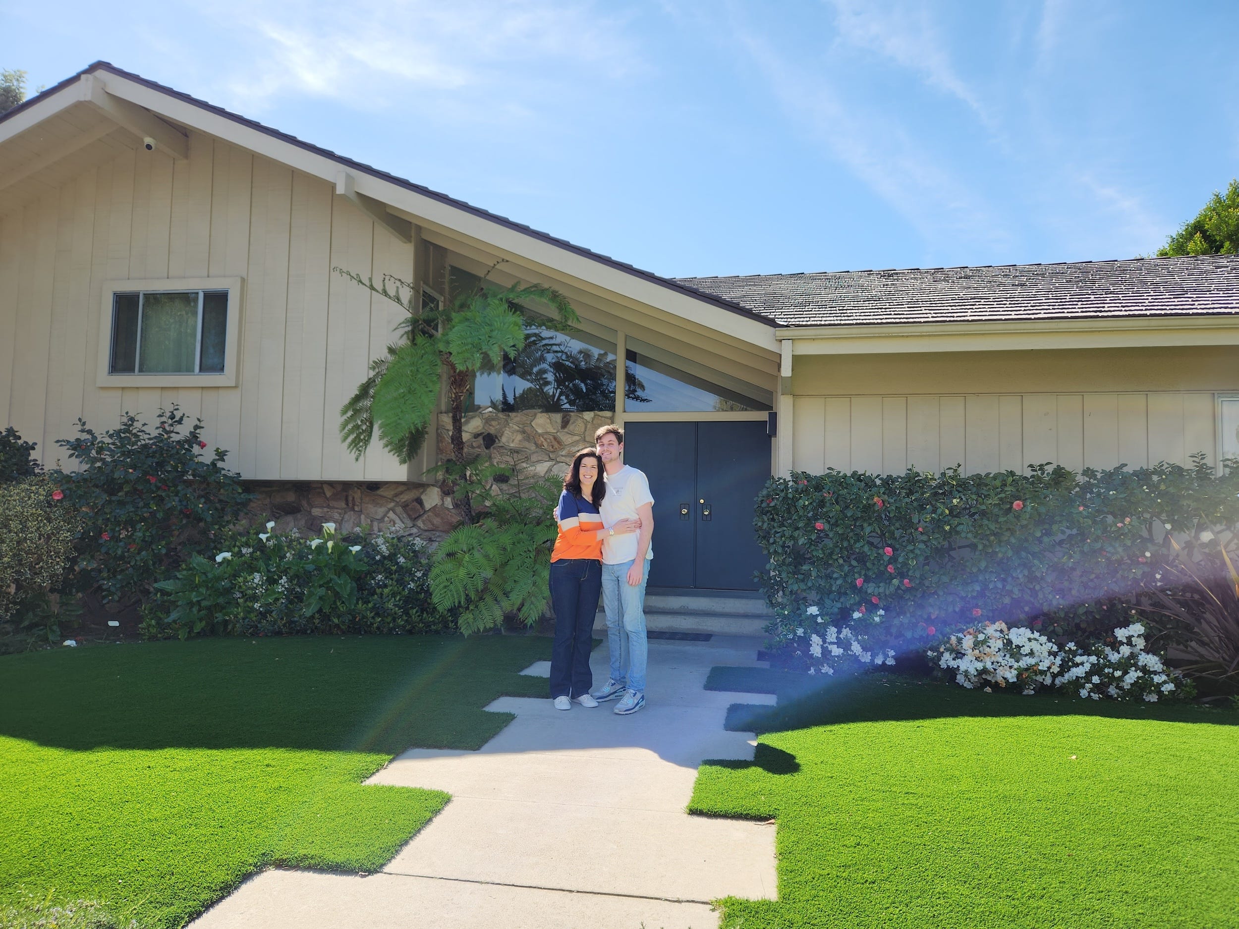 A man and woman outside "the Brady Bunch" house.