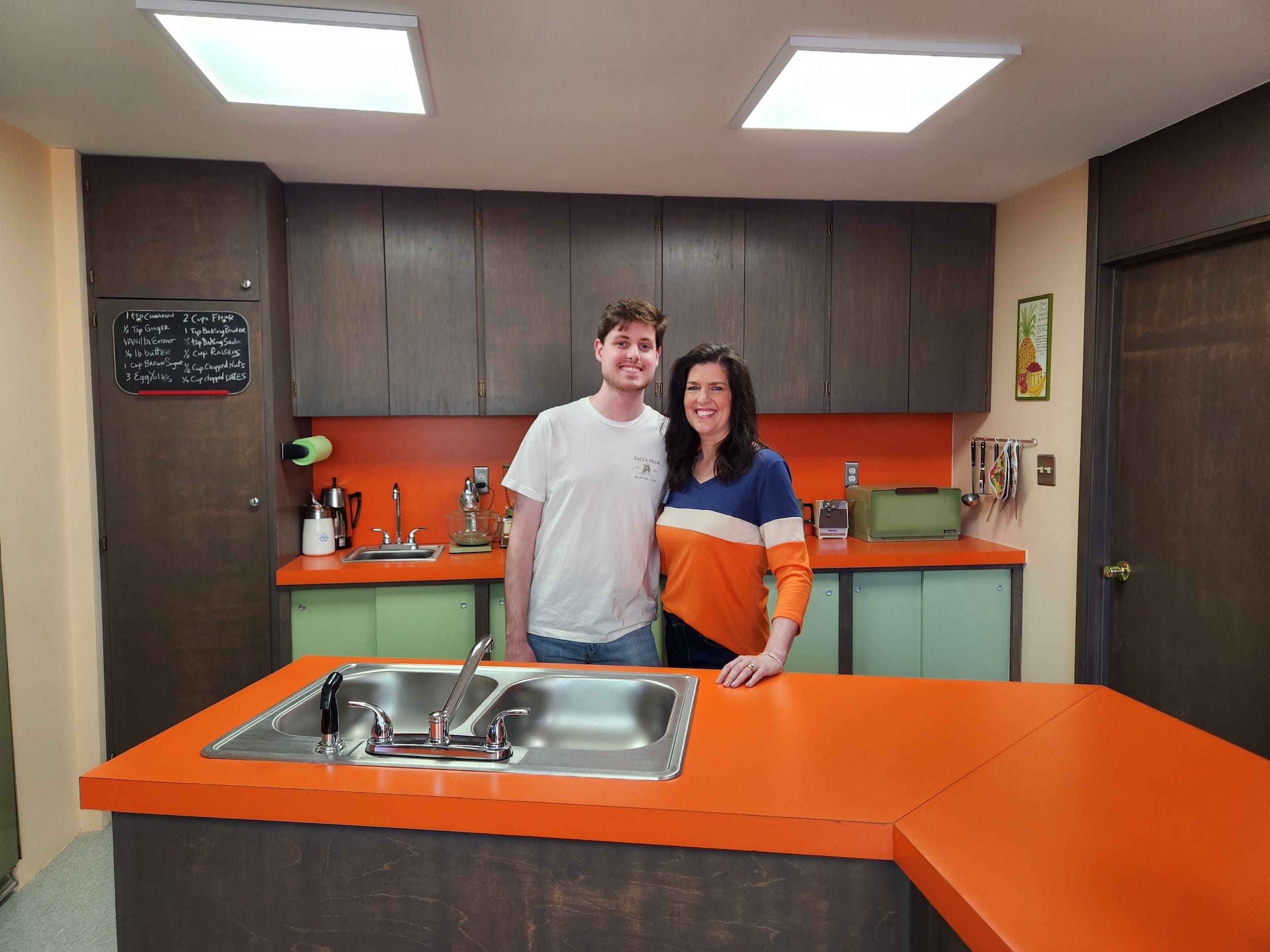 A man and woman standing in a kitchen.