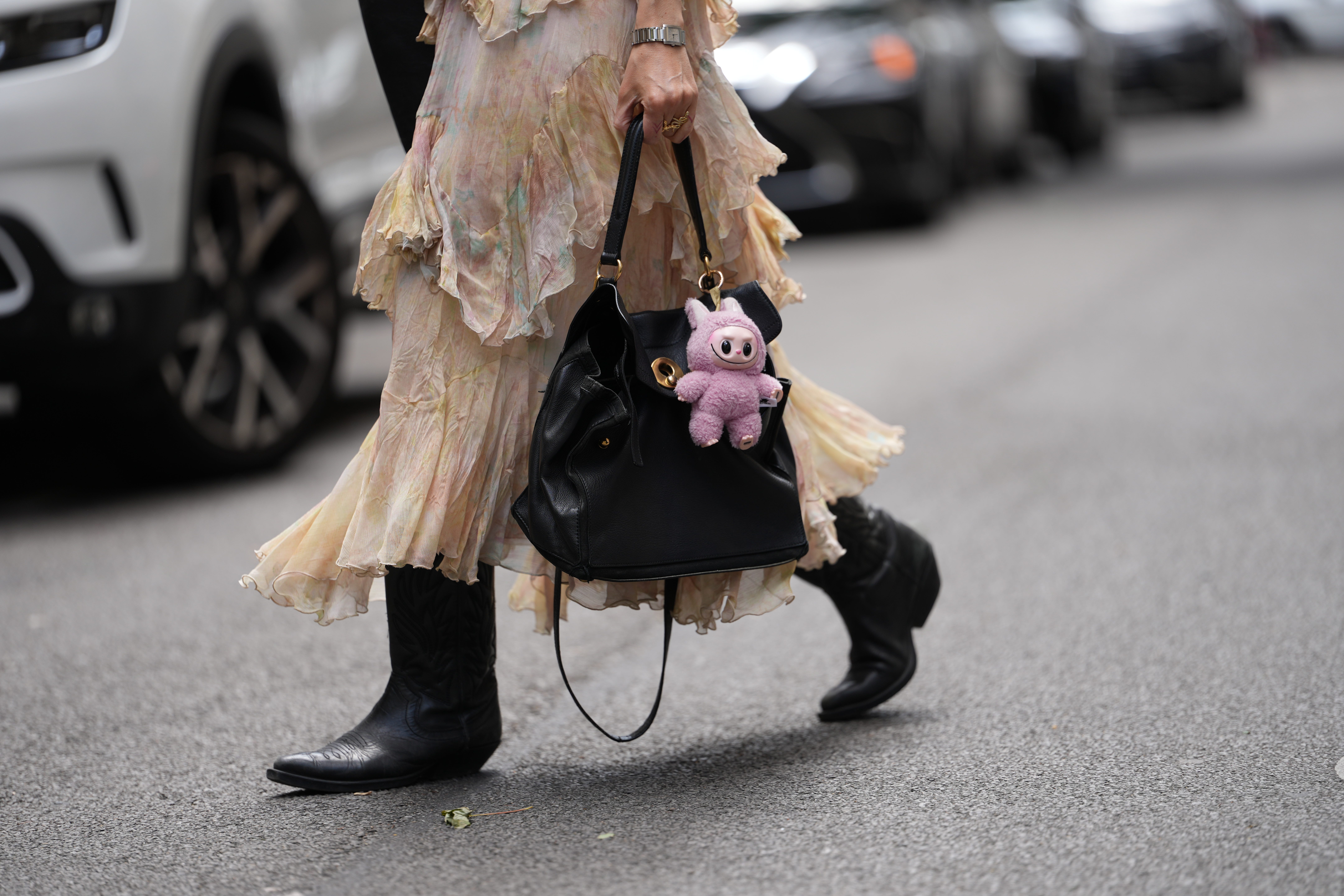 A small pink Labubu toy on a black handbag
