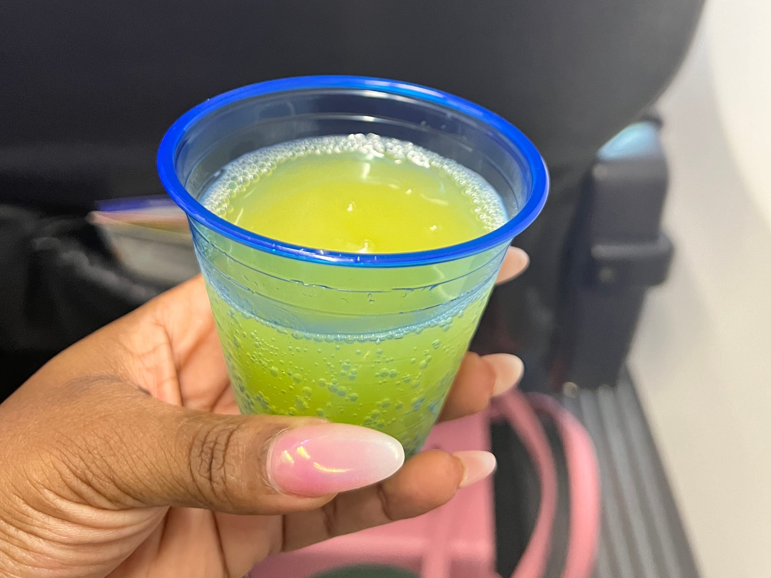 Kachelle holds a small plastic cup with a mimosa inside.
