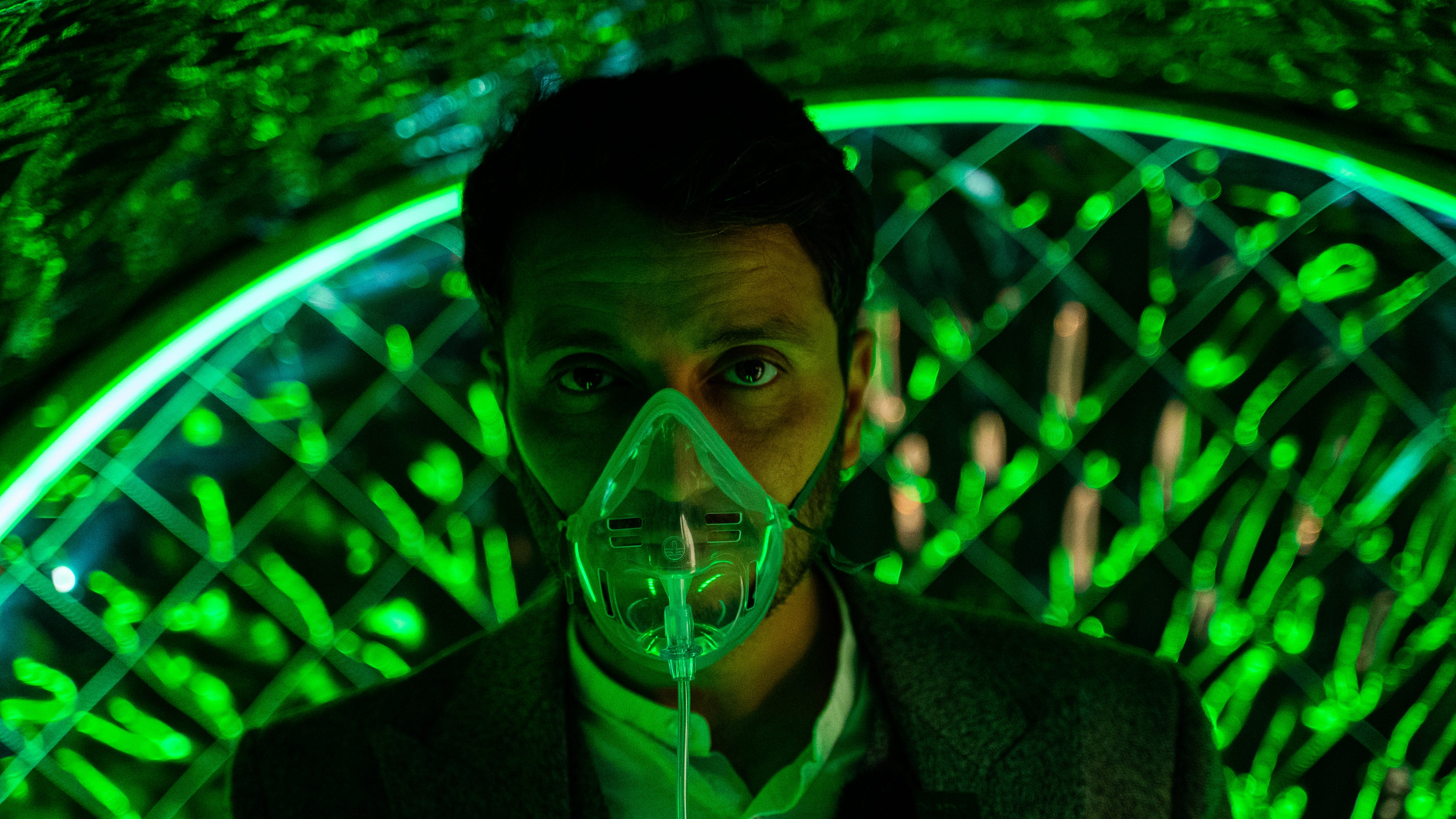 A man wearing an oxygen mask in a futuristic clinic.