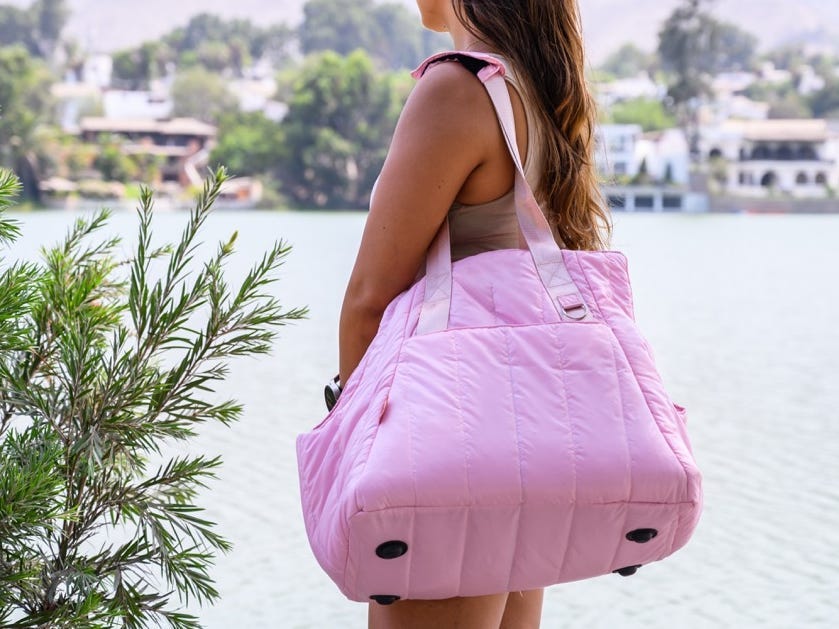 Woman carrying pink duffel bag