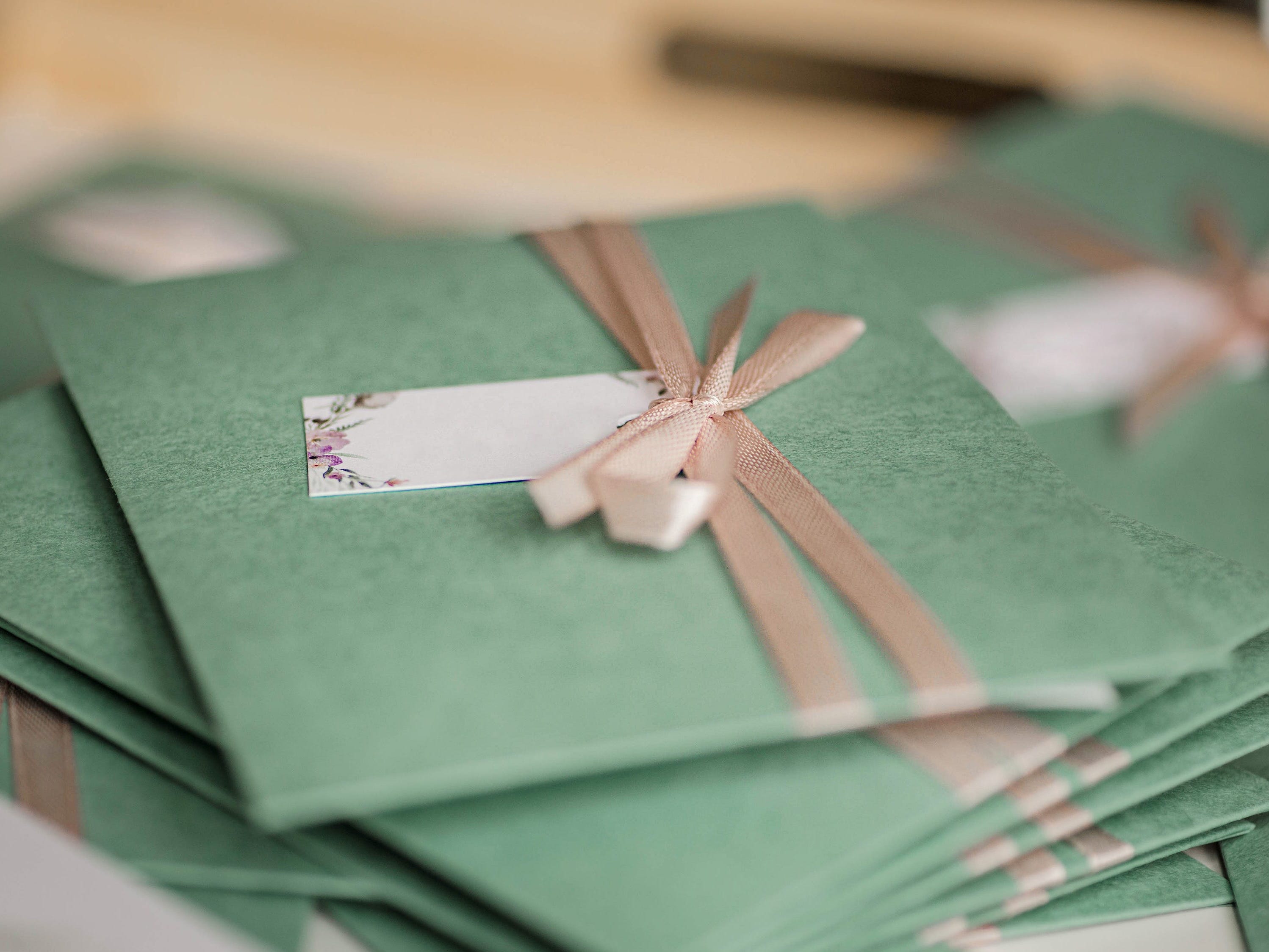 green wedding invitations tied with ribbon