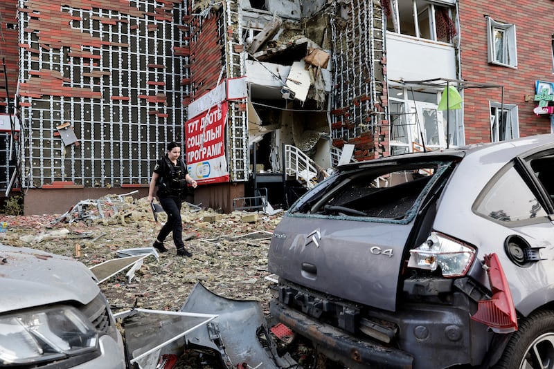 A police investigator walks near a damaged apartment building at the site of a Russian drone strike, amid Russia's attack on Ukraine, in Kyiv, Ukraine June 10, 2025. REUTERS/Thomas Peter     TPX IMAGES OF THE DAY