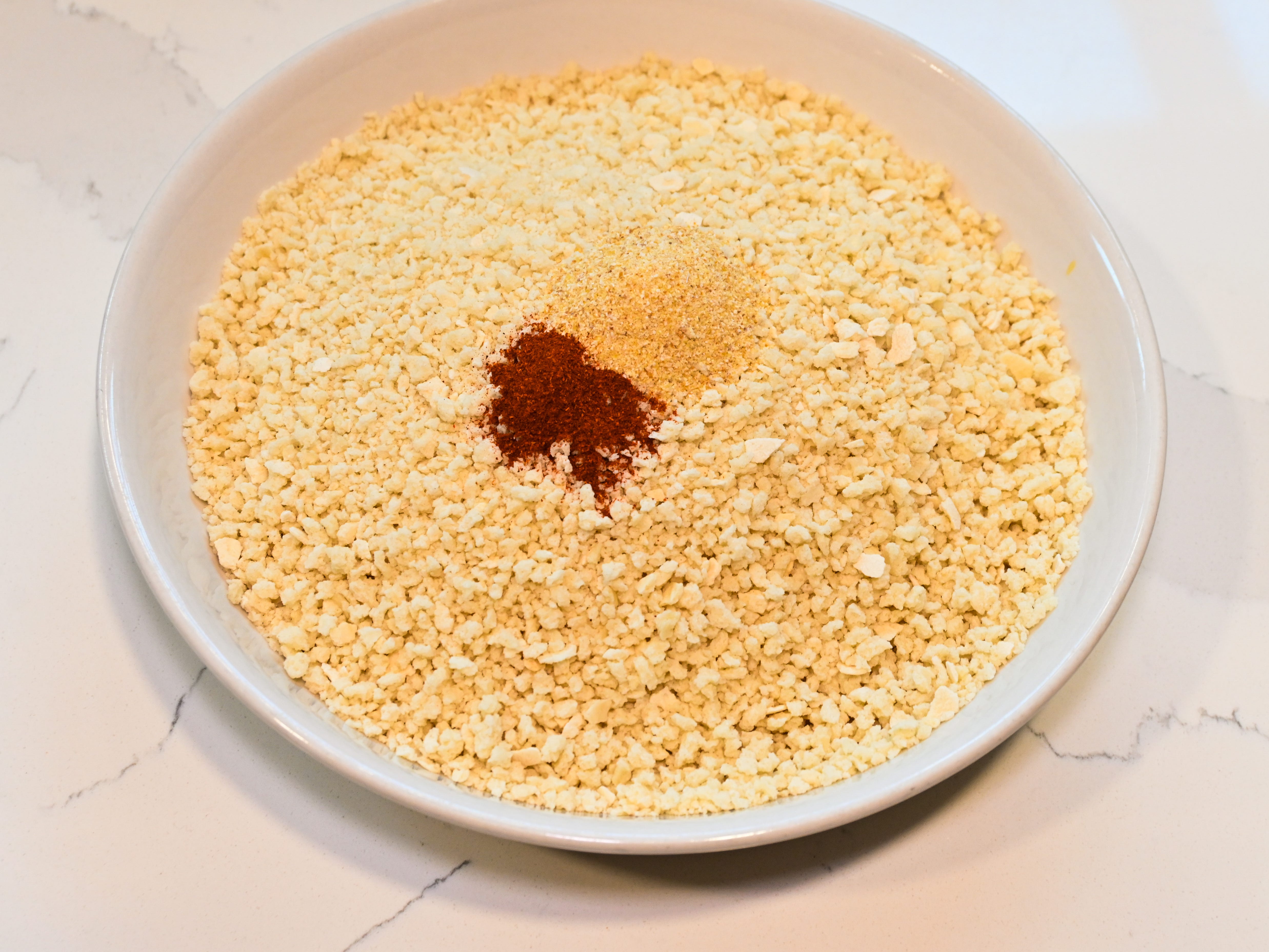 A bowl of panko with some paprika and garlic powder added.