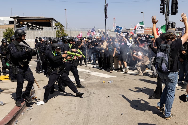 Law enforcement fire less-lethal munitions at protesters during clashes outside the federal building in Los Angeles, California