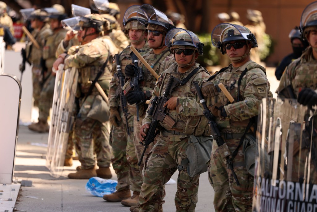 National Guard soldiers in riot gear stand in formation.