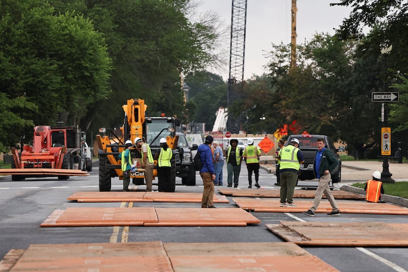 Workers stand near plates lying on the street, used to protect the pavement from potential damage made by maneuvering U.S. Army tanks, as preparations continue for the U.S. Army’s 250th Birthday Festival and Parade in Washington, D.C., U.S., June 8, 2025. REUTERS/Aaron Schwartz