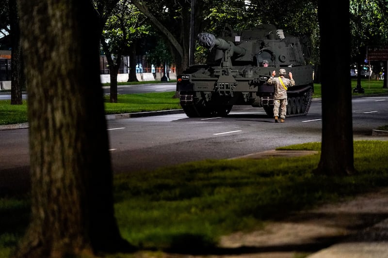 A member of U.S. military gestures near a military vehicle to be used in the U.S. Army's 250th Birthday celebration and Parade in Washington, D.C., U.S., June 10, 2025. REUTERS/Kent Nishimura