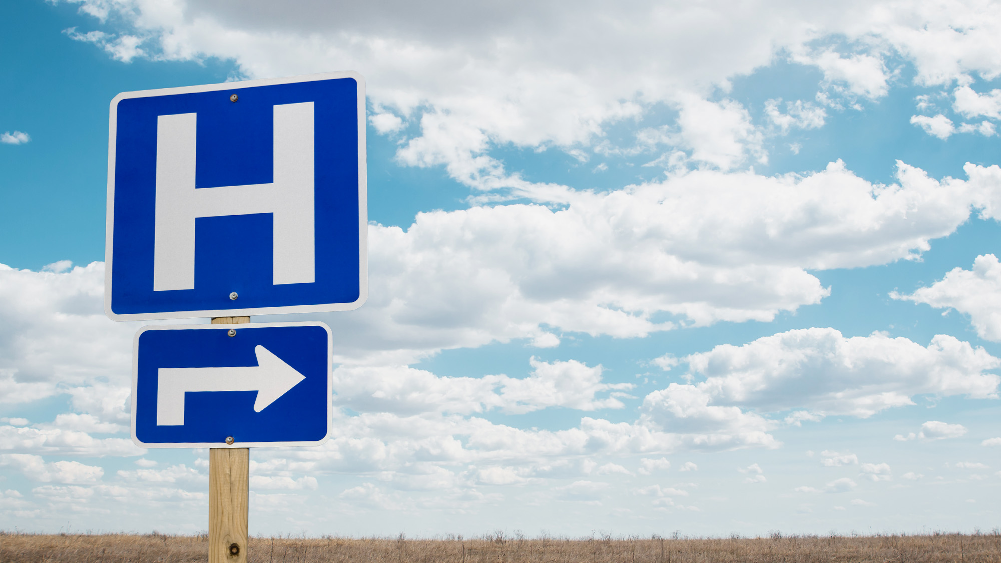 Hospital road sign in an open field.