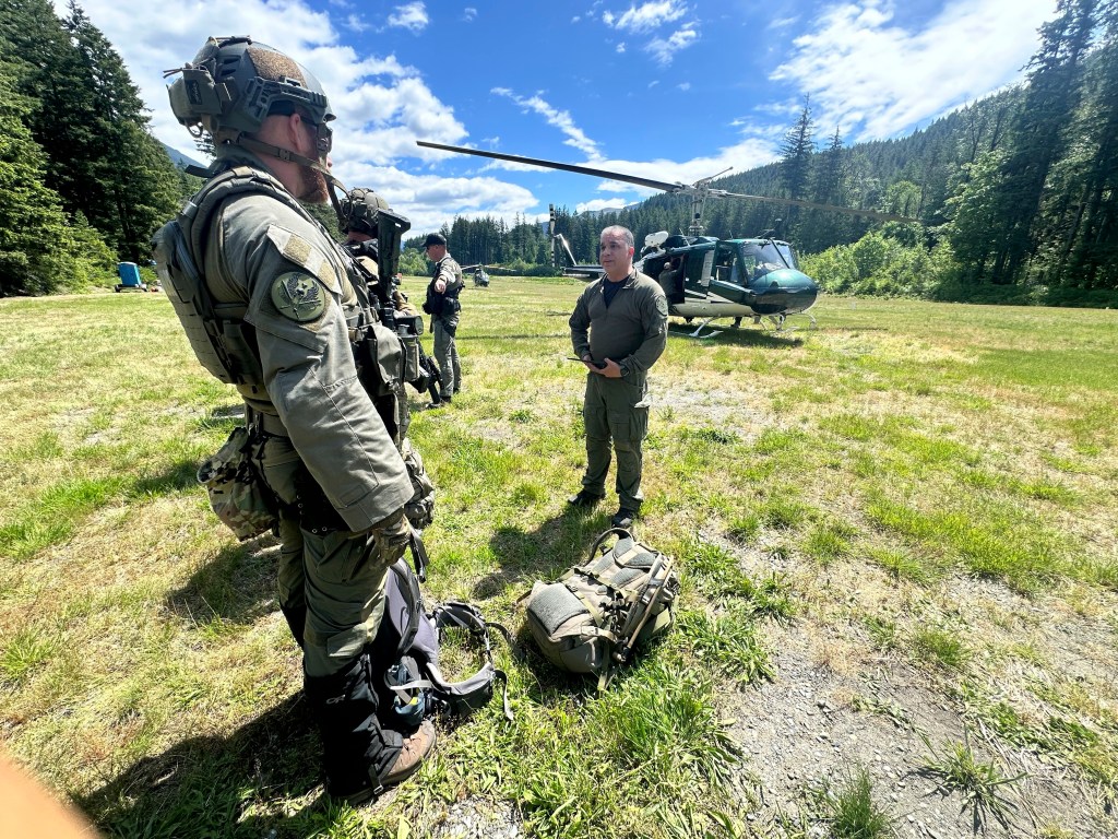 Law enforcement officers and a helicopter at a search operation.
