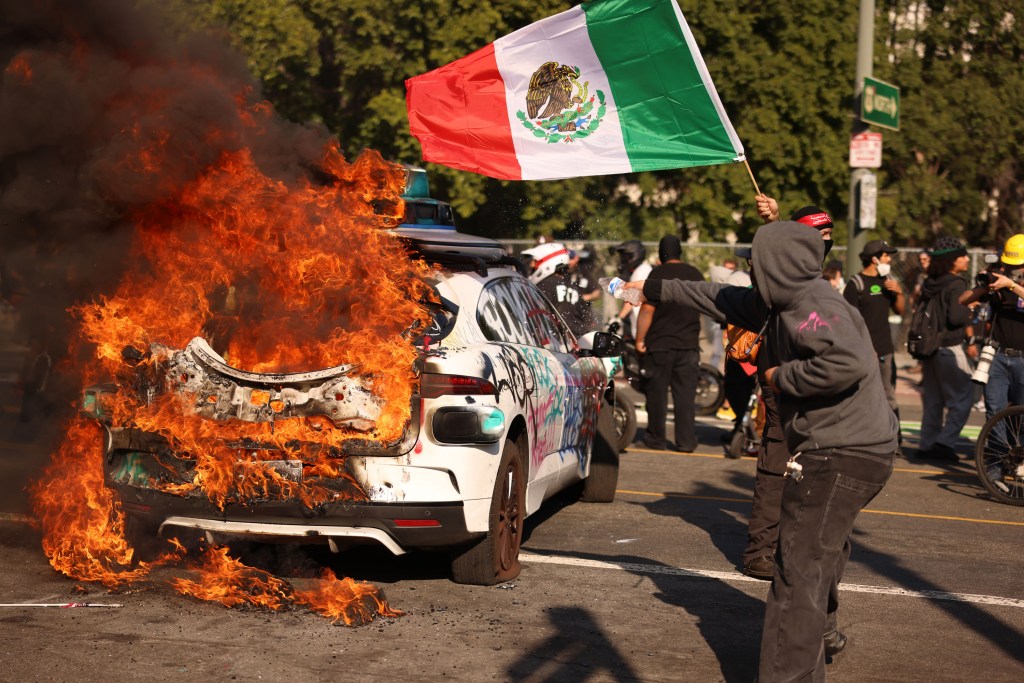A burning car in downtown Los Angeles during a protest.