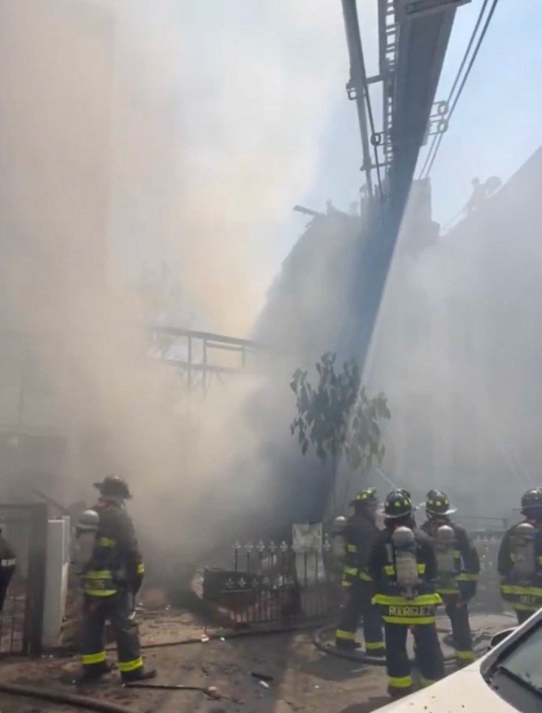 Firefighters battling a three-alarm fire at a three-story building.