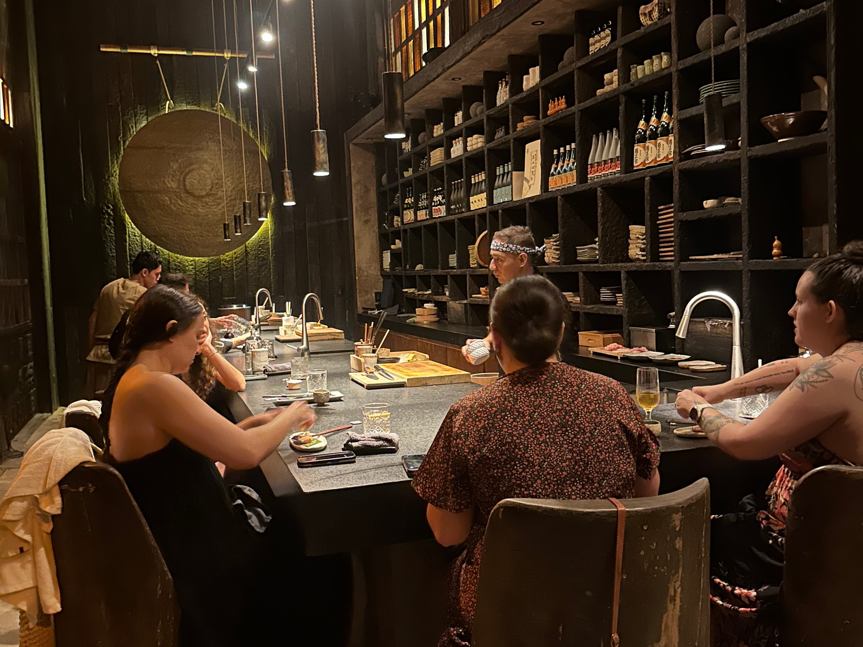 People sitting around table in dimly lit restaurant