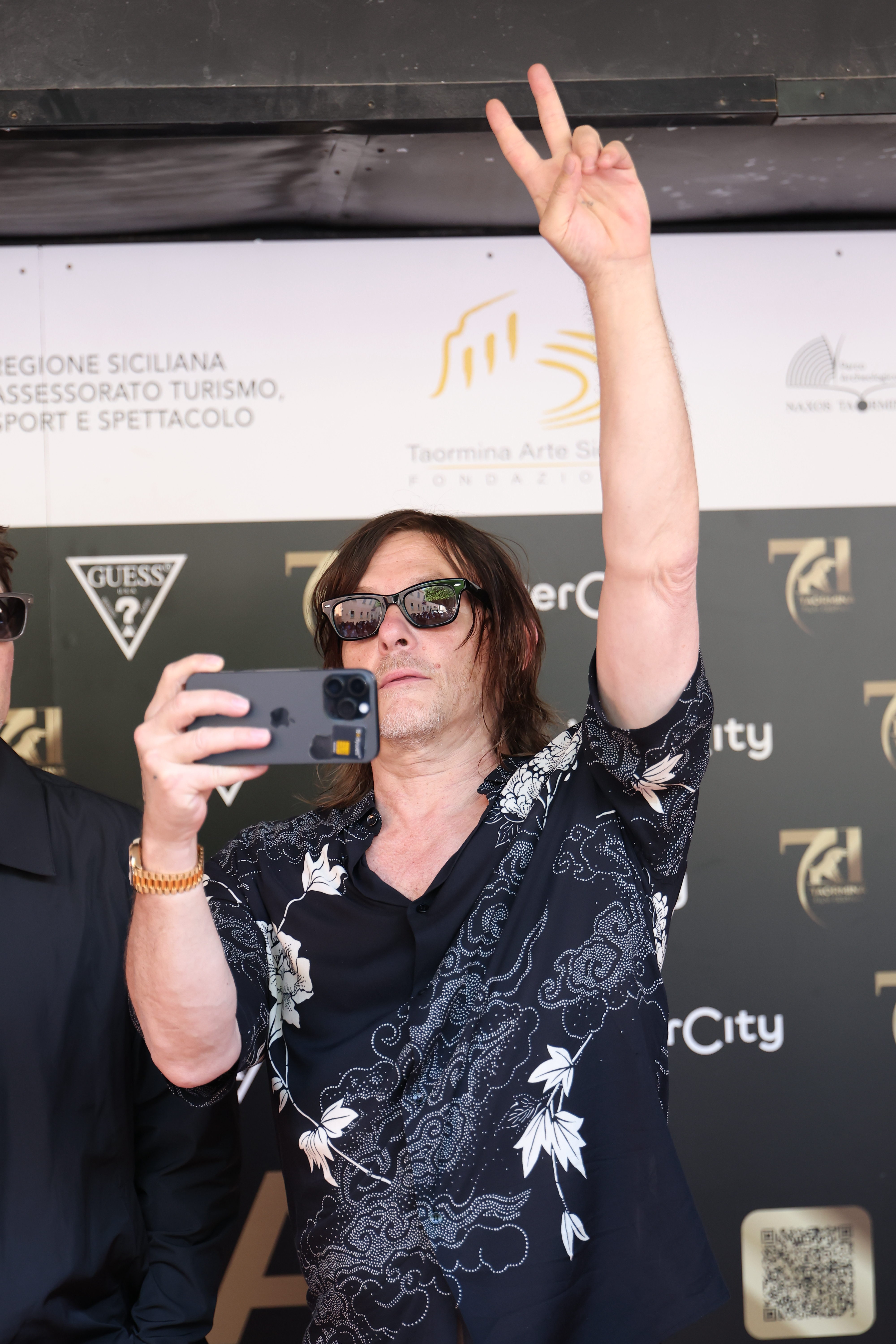 Norman Reedus films the crowd during a photocall at the 71st Taormina Film Festival in Italy.