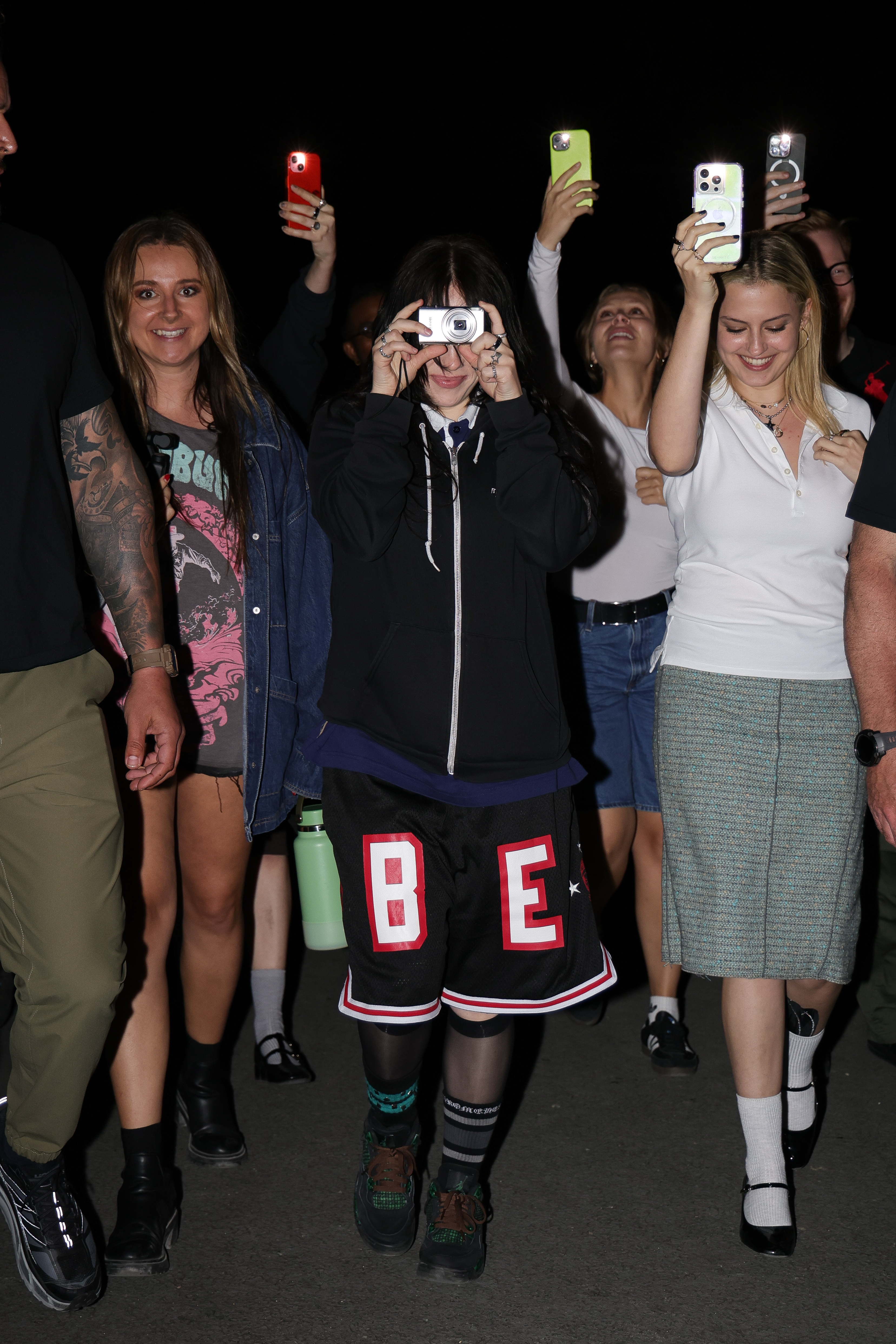 Billie Eilish films the crowd while leaving a chaotic dinner in Paris.