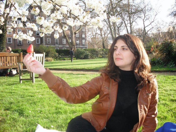 Author Julie Kling holding a strawberry in Mecklenburgh Garden