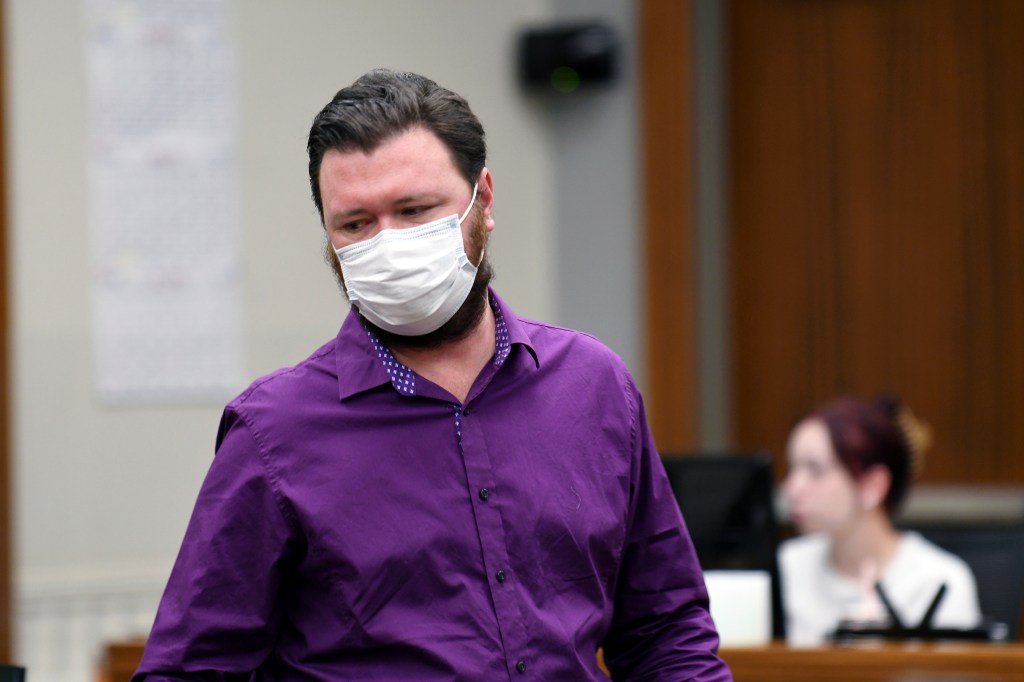 Miles Harford in court wearing a purple shirt and face mask.