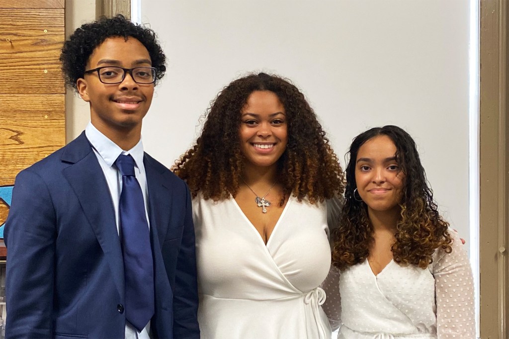 Three siblings posing for a photo.