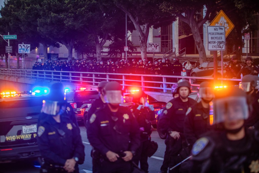 California Highway Patrol officers take over a street to close the bridges to the 101 Freeway after curfew on June 10, 2025.