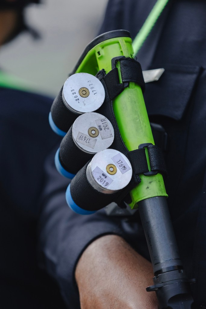 A police officer holds a less lethal munition launcher outside a federal building during a protest in Los Angeles.