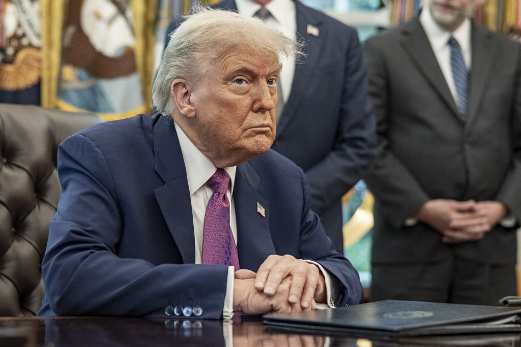 President Trump sitting at the Oval Office desk.