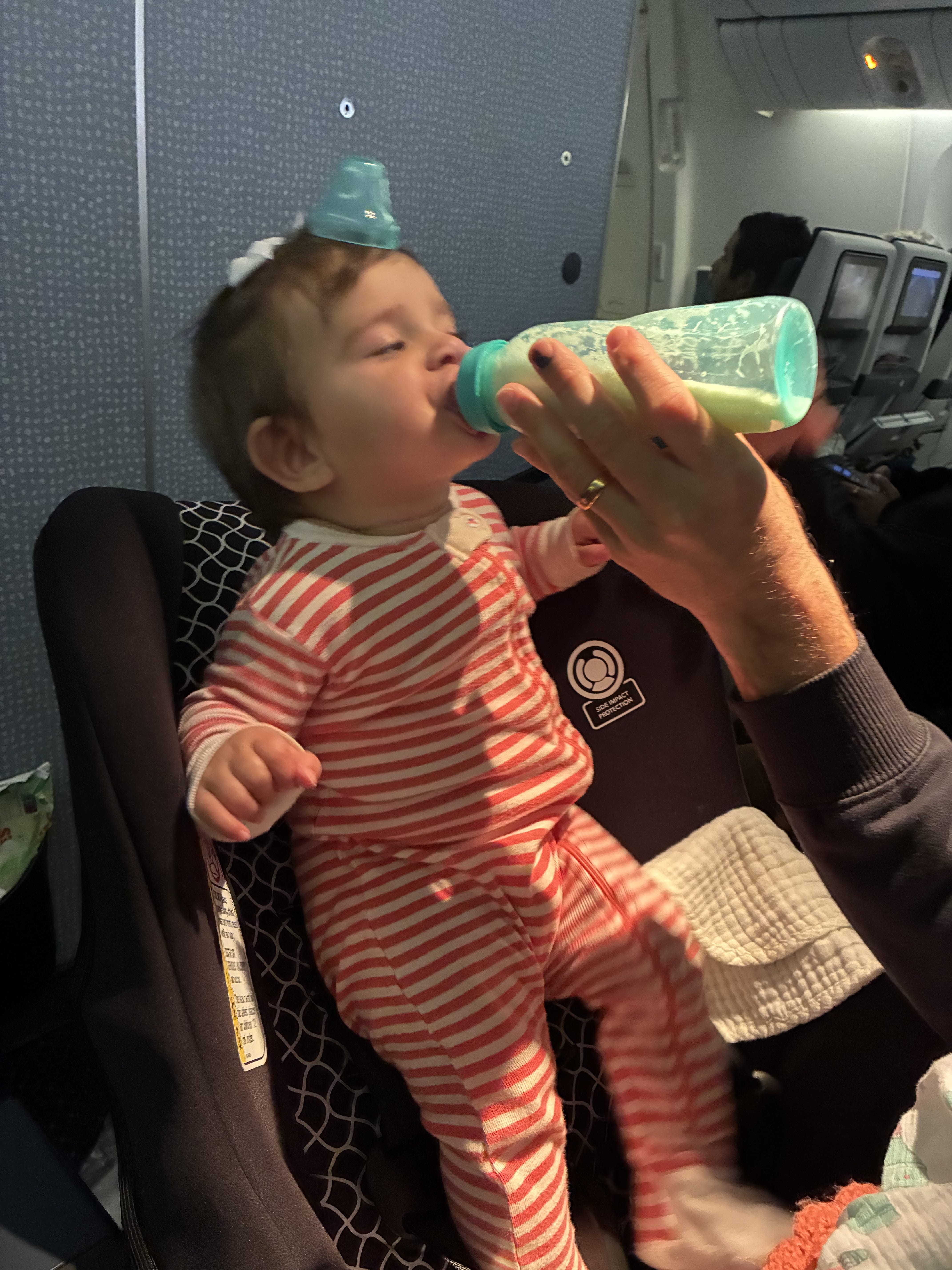 infant on plane drinking from a bottle