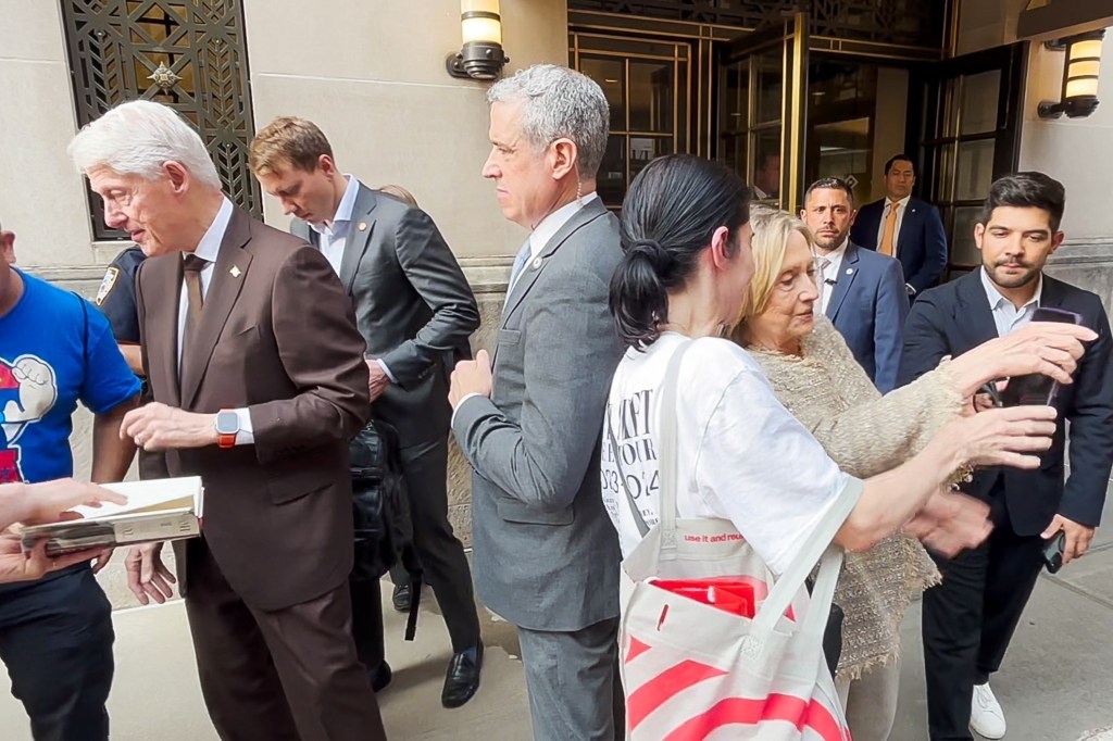 Bill and Hillary Clinton signing autographs for supporters in New York City.