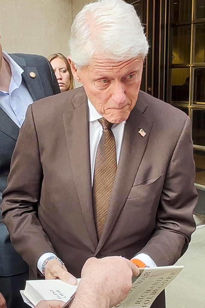 Bill Clinton signing a book.