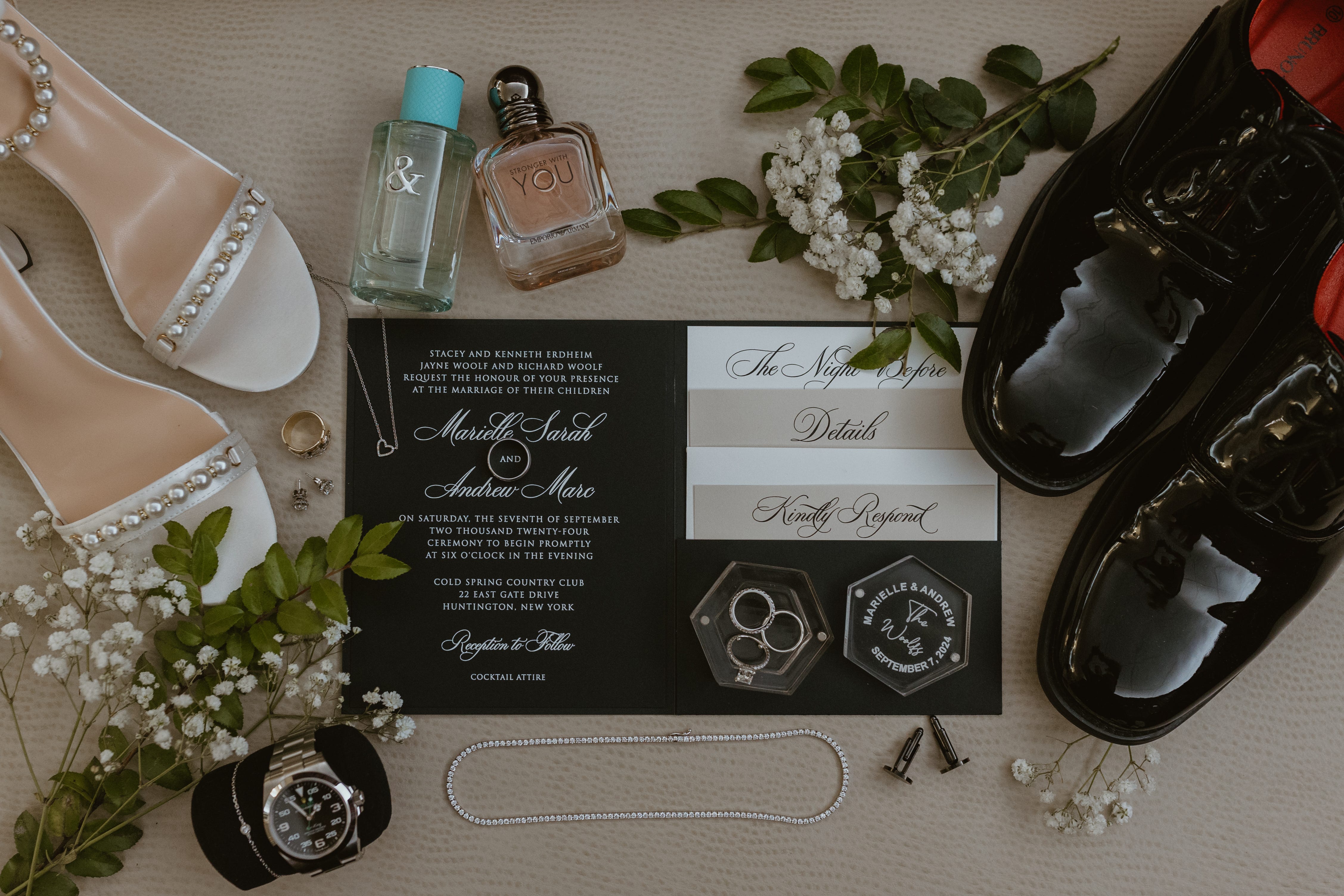 A detail shot of shoes, rings, fragrances, and an invitation for Marielle and Andrew's wedding.