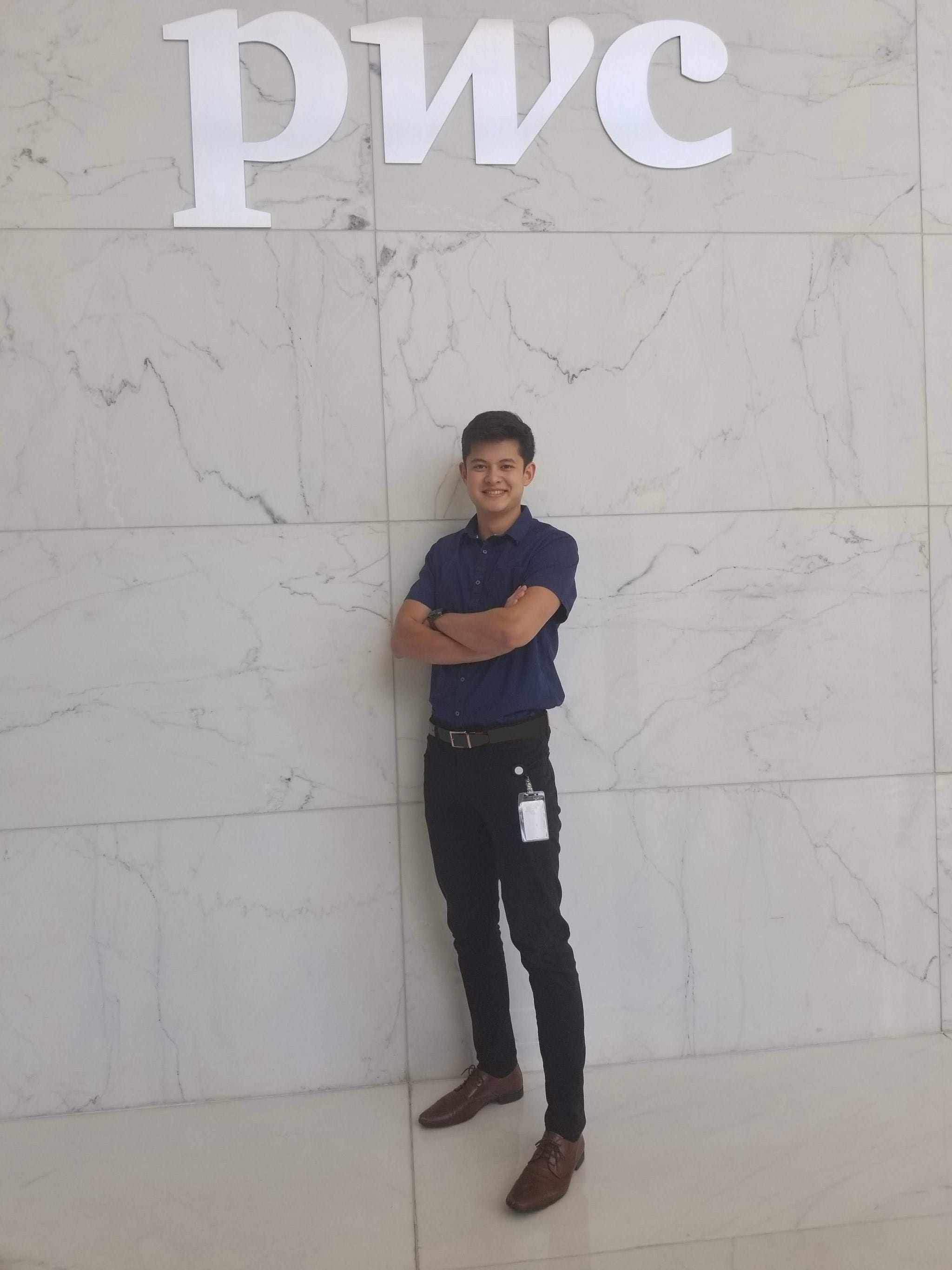 Donald King standing with his arms crossed in front of a PwC logo