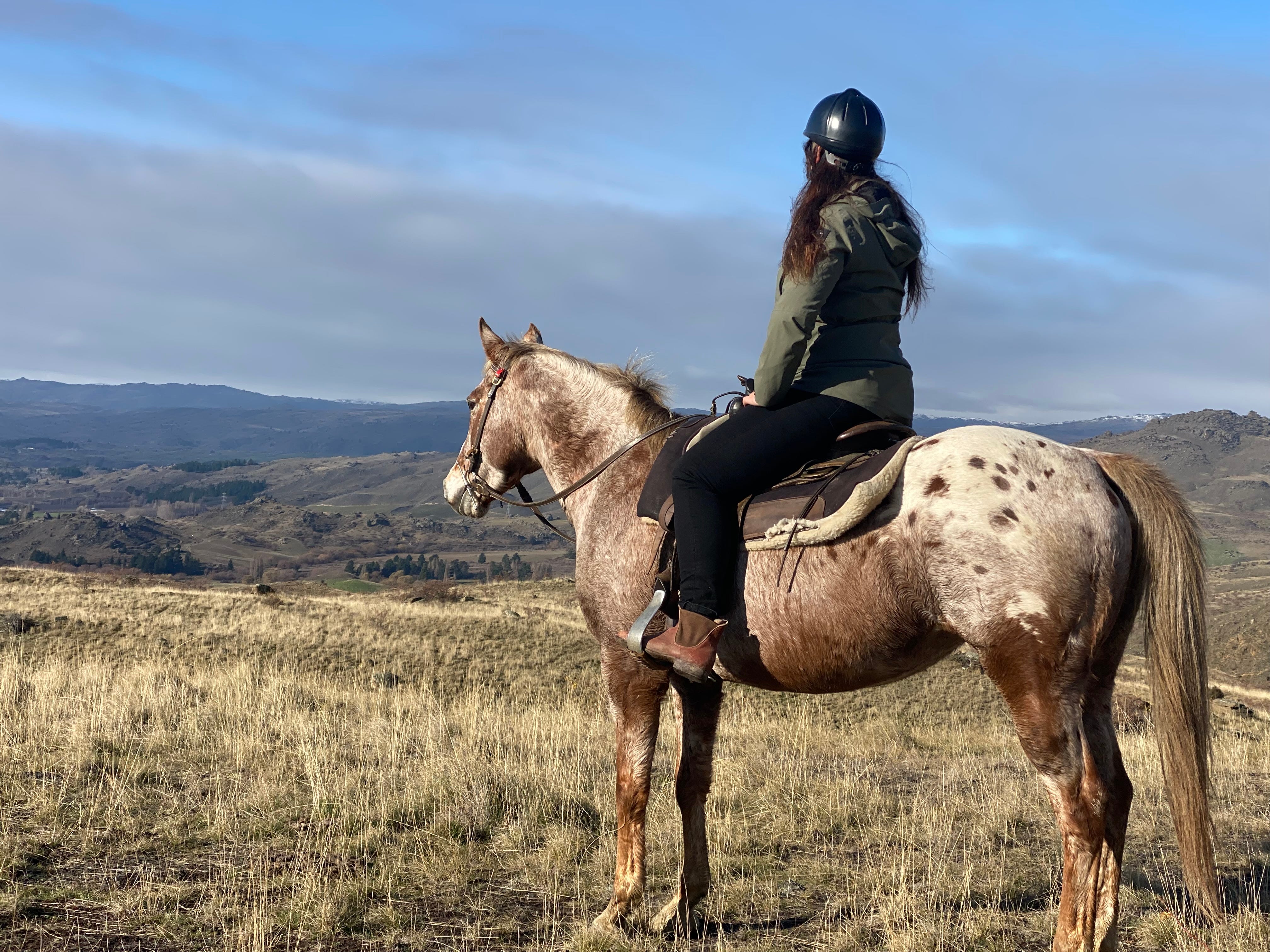The author on a horse with her back to the camera.