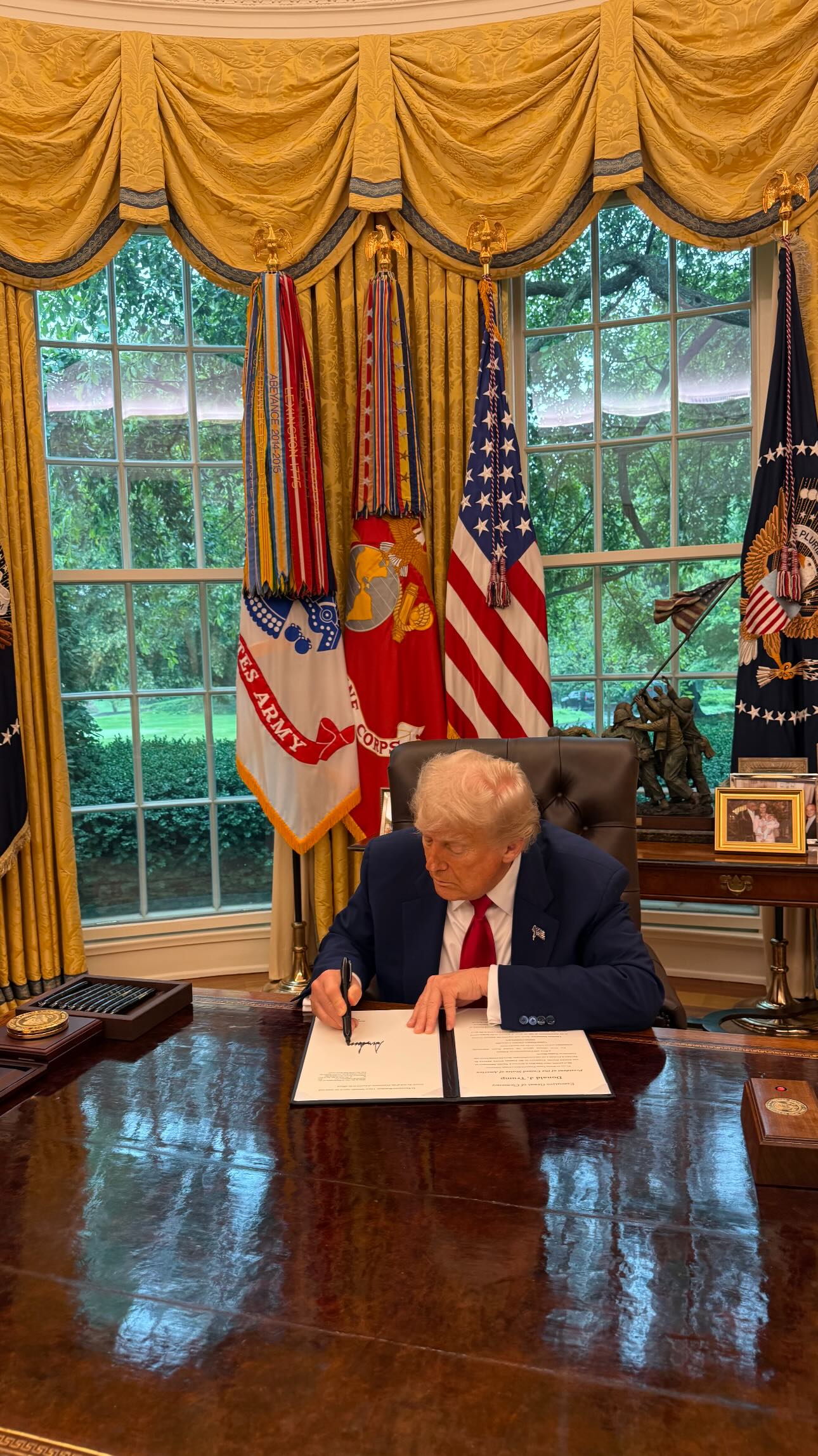 President Donald Trump. signs an order in the Oval Office. 