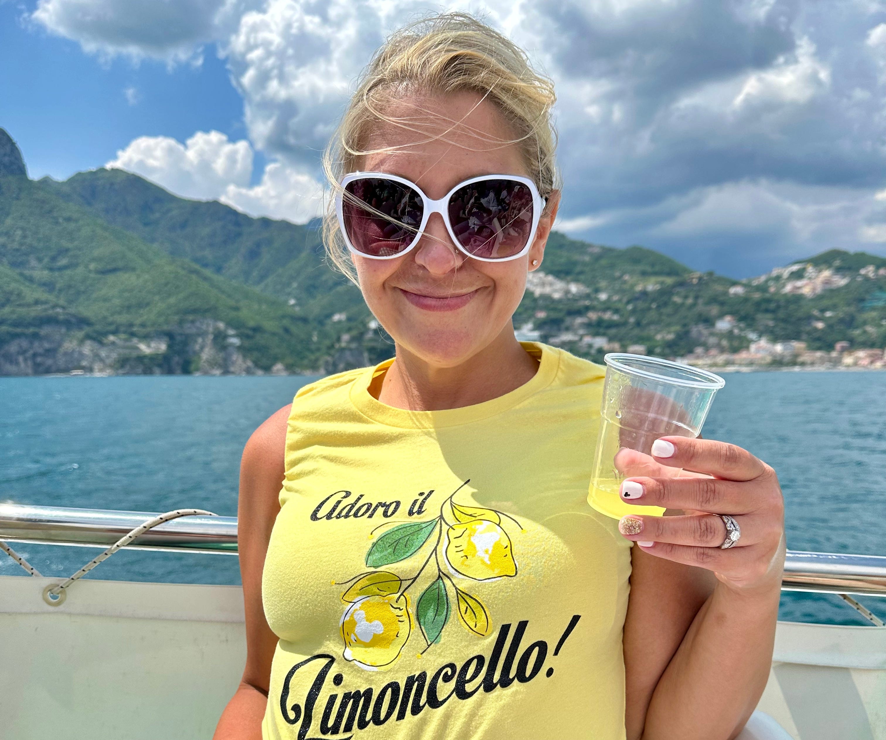 A woman on a boat in Italy drinking a limoncello.