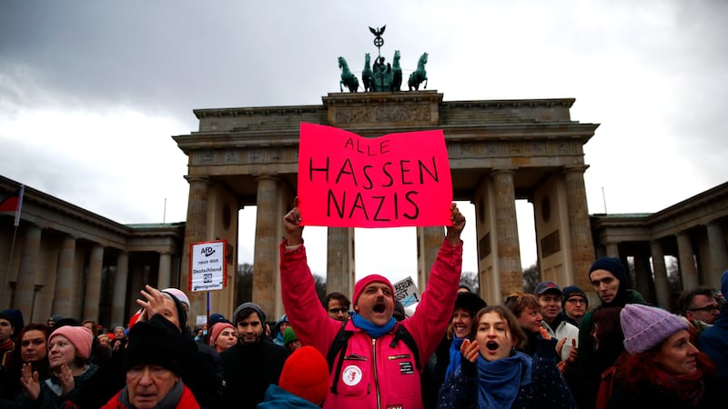 A demonstrator holds a placard in German saying "Everyone hates Nazis" during a pro-democracy demonstration following reports that members of the Alternative for Germany (AfD) political party had recently met with known neo-Nazis.