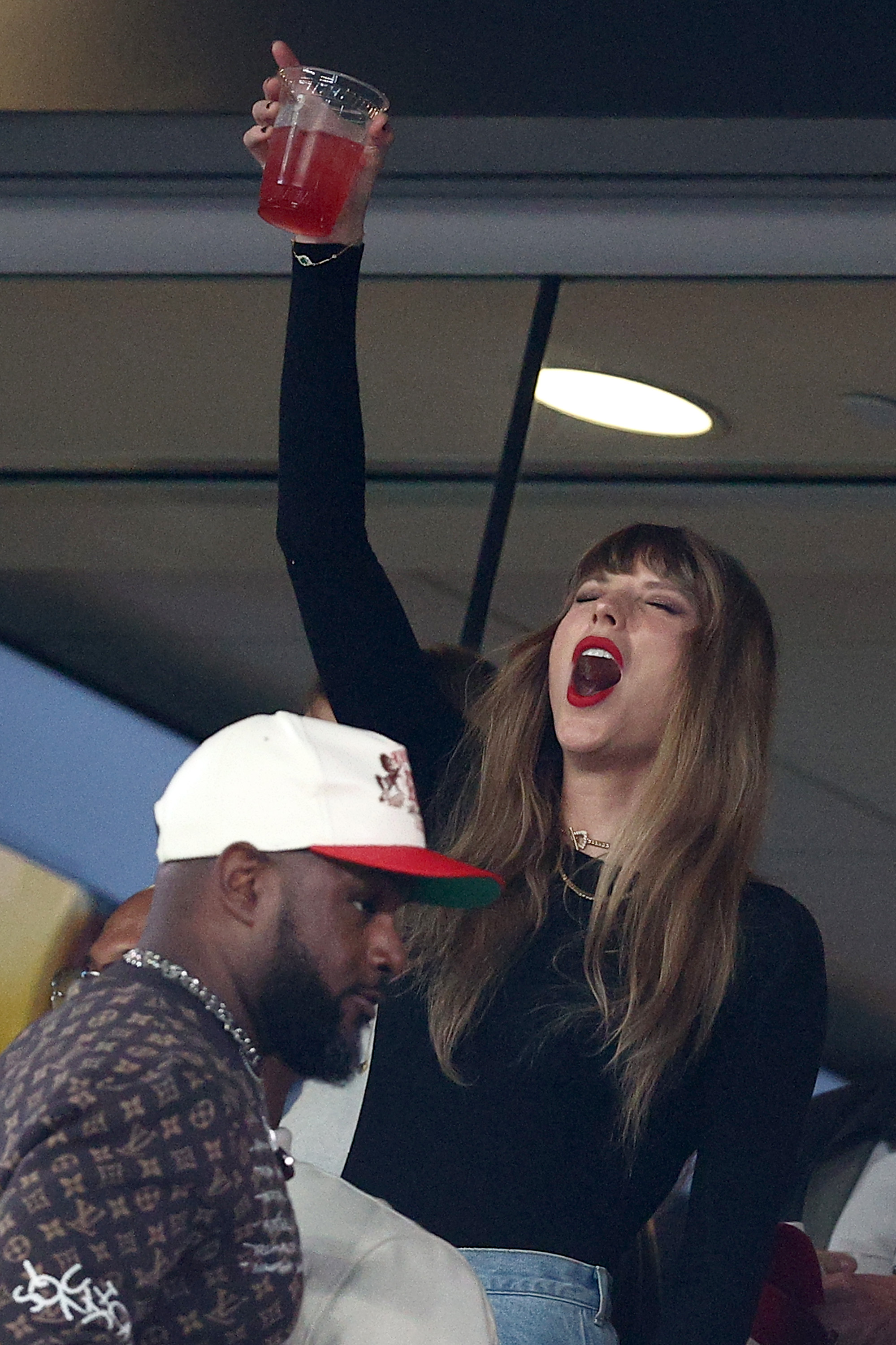 Taylor Swift shouts in a statium suite. 
