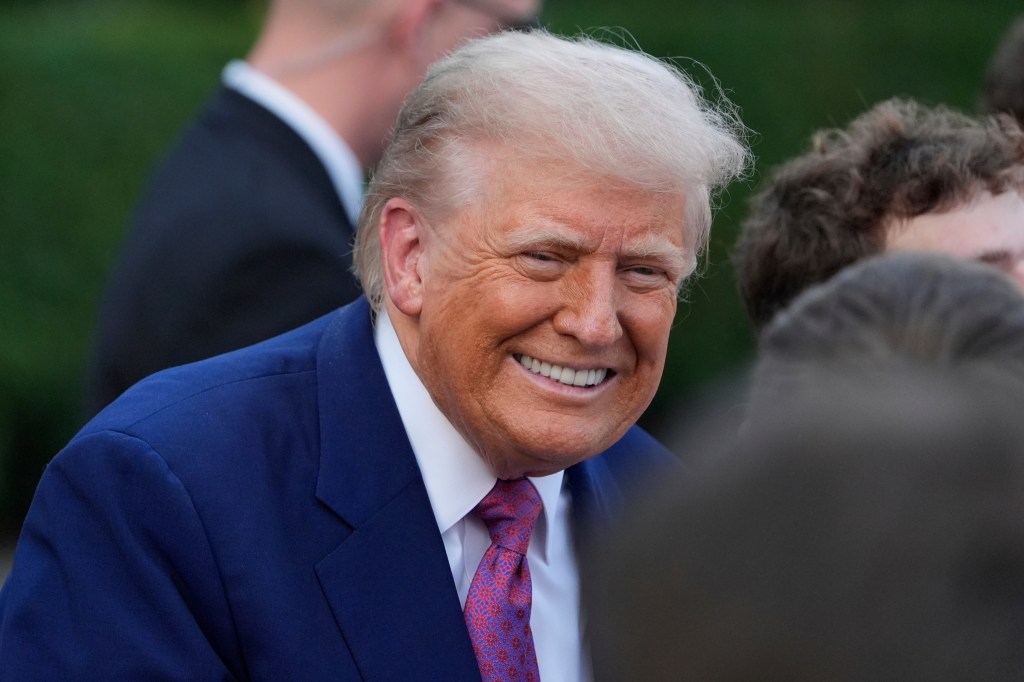 Donald Trump smiling and greeting guests.