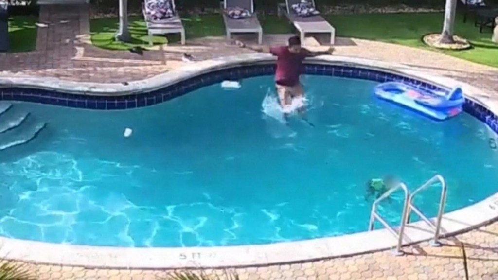 Surveillance video of a man rescuing a child from a swimming pool.