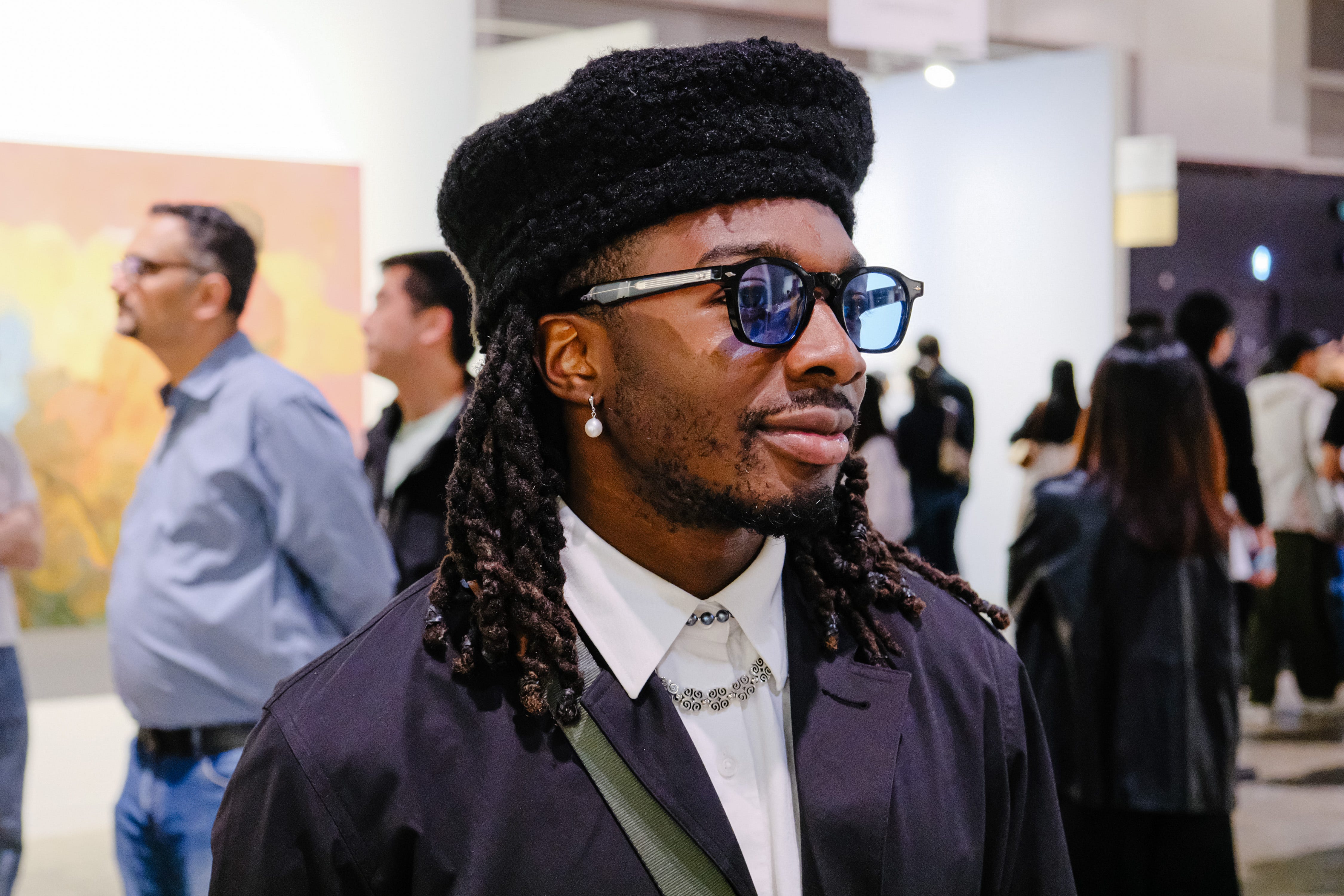 A person at Art Basel 2025 wears Jacques Marie Mage glasses and a Beekite hat.