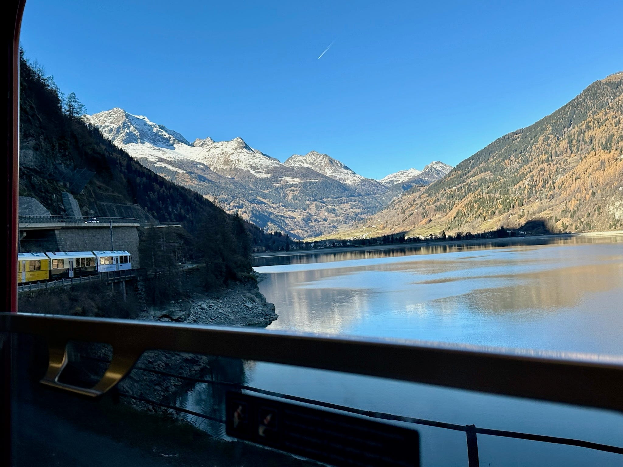 View of water with mountains in distance from a train