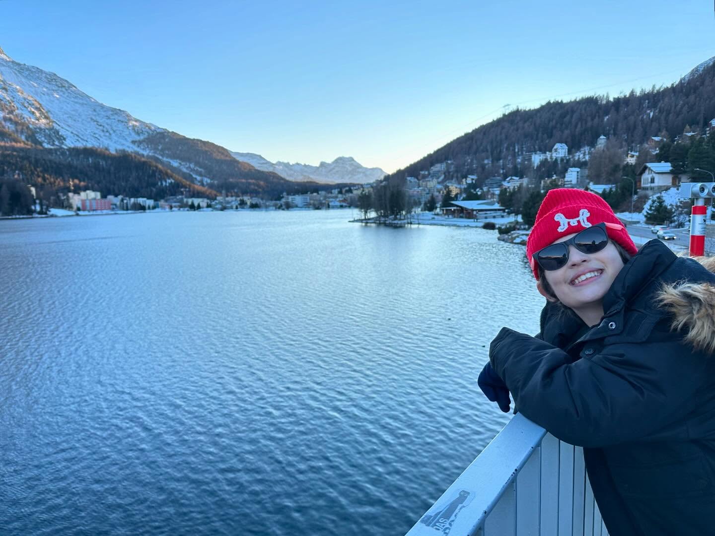 Person smiling with sunglasses on next to water in St Moritz