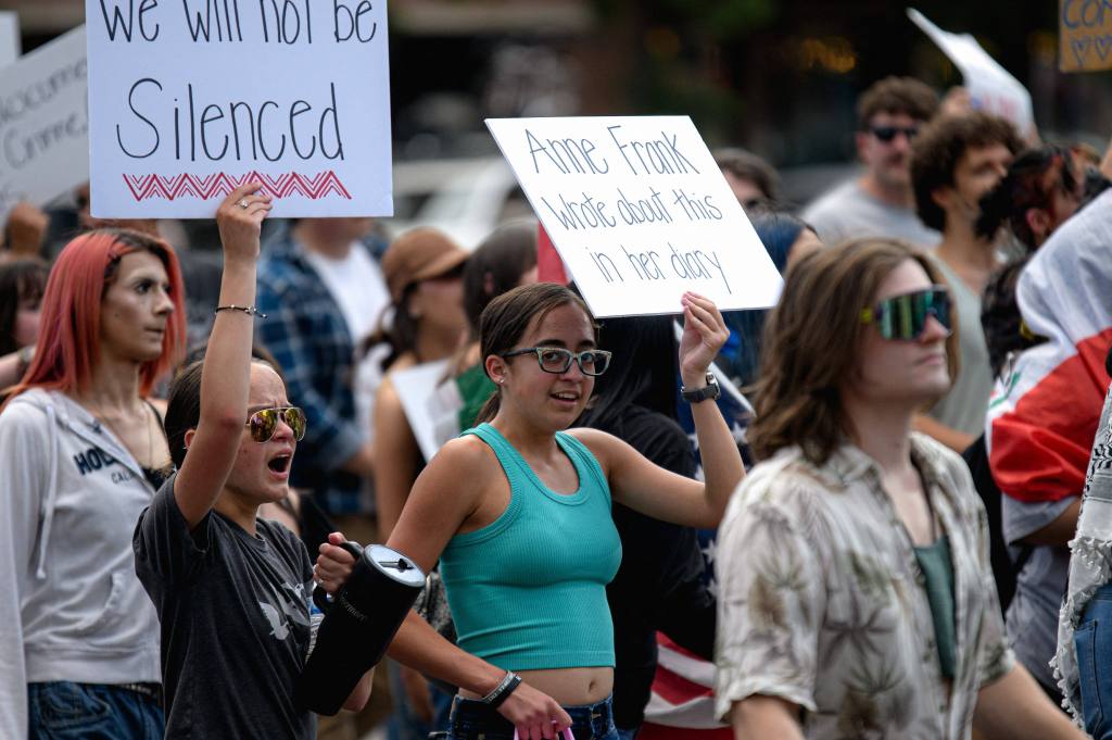 Protestors at a Salt Lake City rally hold signs against ICE.