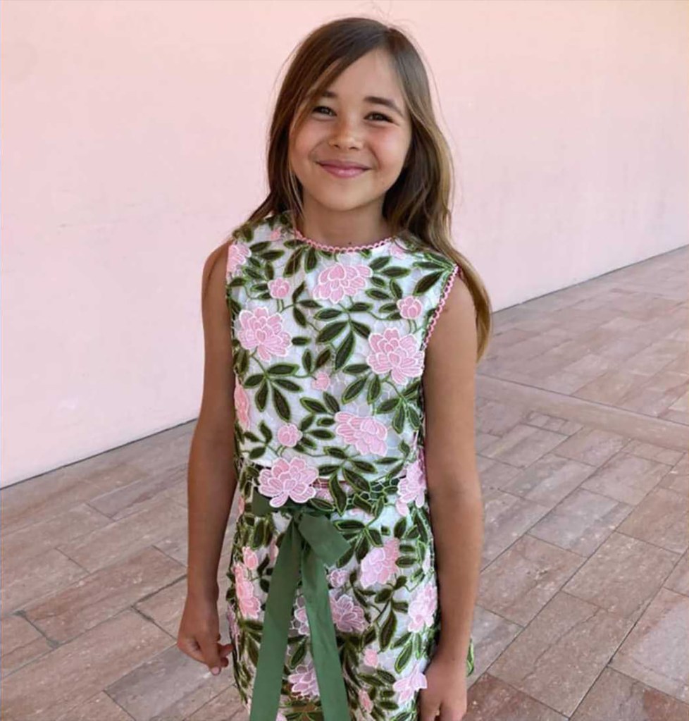 A 9-year-old girl in a floral dress.